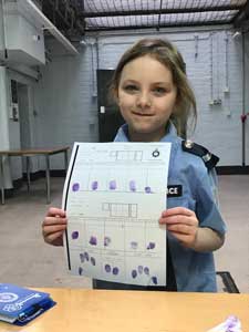 child holding up a sheet with her finger prints